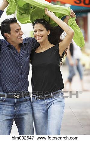 Couple holding raincoat over heads View Large Photo Image Stock Photo - Couple holding raincoat over heads. Fotosearch
