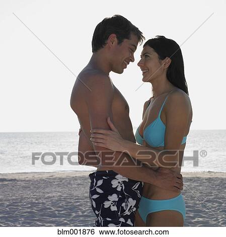 Stock Photograph - Couple hugging at beach. Fotosearch