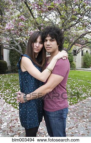 Picture - Couple hugging near tree with spring blossoms. Fotosearch