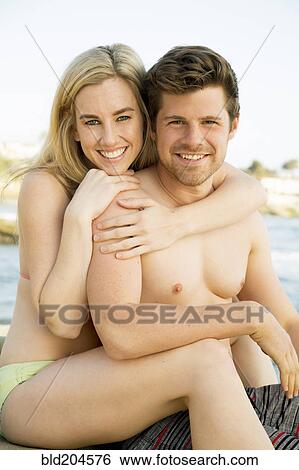 Stock Photograph - Couple hugging on beach. Fotosearch