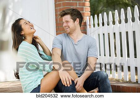 Couple laughing together outdoors View Large Photo Image Stock Image - Couple laughing together outdoors. Fotosearch