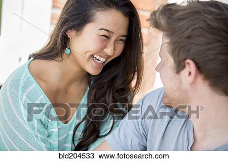 Couple laughing together outdoors View Large Photo Image Stock Image - Couple laughing together outdoors. Fotosearch