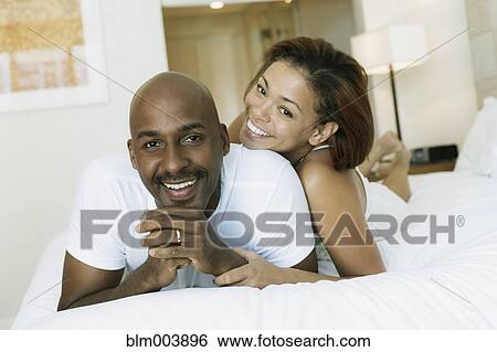 Couple laying on bed View Large Photo Image Stock Photograph - Couple laying on bed. Fotosearch