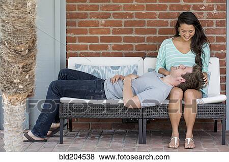 Stock Photo - Couple relaxing together on bench. Fotosearch