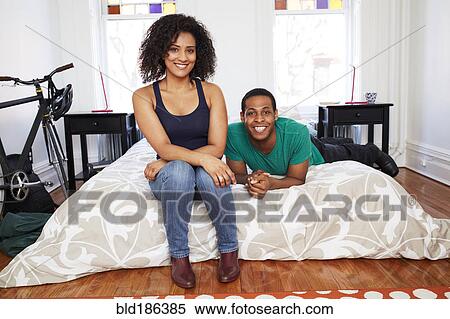 Stock Photography - Couple smiling on bed. Fotosearch