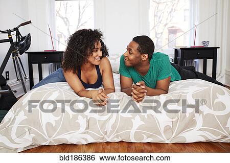 Stock Photograph - Couple talking on bed. Fotosearch
