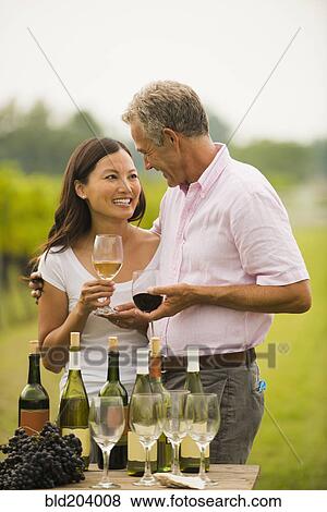Stock Photo - Couple tasting wine together outdoors. Fotosearch