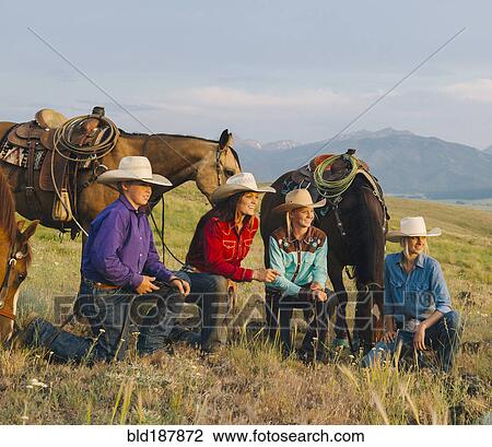 Stock Image - Cowboy and cowgirls with horses on ranch. Fotosearch