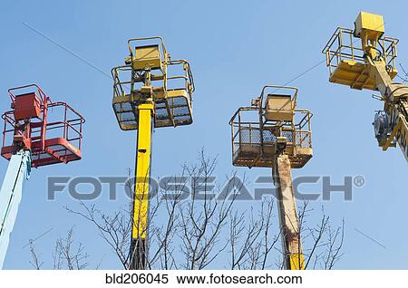 Cranes with basket platforms for workers at height View Large Photo Image Stock Photography - Cranes with basket platforms for workers at height. Fotosearch