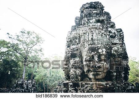 Stock Photo - Dilapidated statue and pillar at Angkor Wat, Siem Reap, Cambodia. Fotosearch