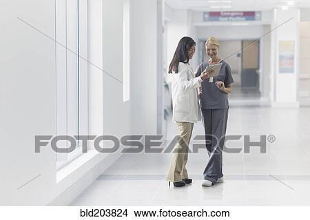 Picture - Doctor and nurse talking in hospital. Fotosearch