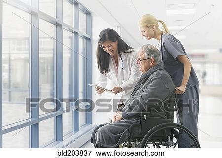 Doctor and nurse talking to patient in hospital View Large Photo Image Stock Photo - Doctor and nurse talking to patient in hospital. Fotosearch