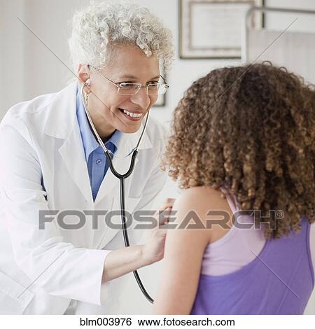 Stock Photograph - Doctor checking girlÆs heart with stethoscope. Fotosearch