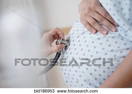Doctor listening to belly of pregnant woman View Large Photo Image Stock Image - Doctor listening to belly of pregnant woman. Fotosearch