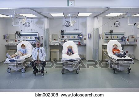Stock Photo - Doctor next to children in hospital beds. Fotosearch
