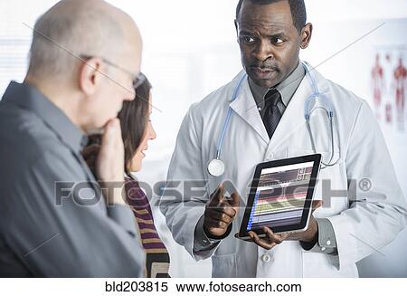Stock Photography - Doctor showing tablet computer to patients. Fotosearch