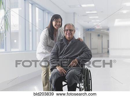 Stock Photo - Doctor smiling with patient in hospital. Fotosearch