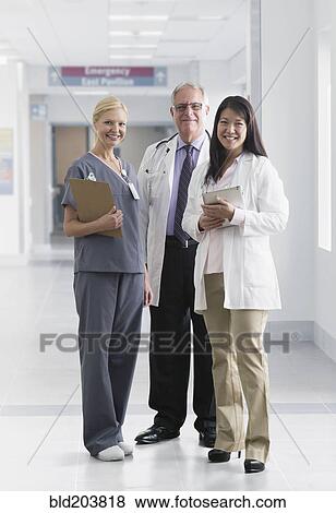 Stock Photo - Doctors and nurse smiling in hospital. Fotosearch