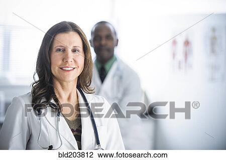 Stock Image - Doctors standing in office. Fotosearch