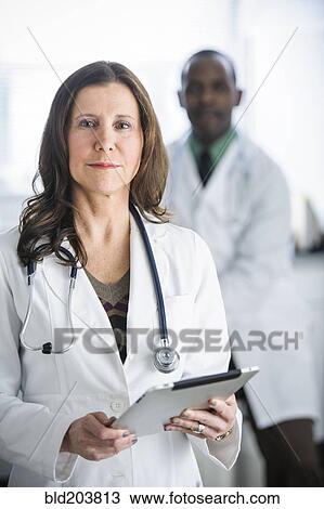 Stock Image - Doctors standing in office. Fotosearch