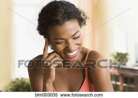 Stock Photography - Embarrassed African woman smiling. Fotosearch
