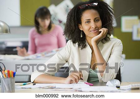 Stock Image - Ethiopian businesswoman sitting at desk. Fotosearch