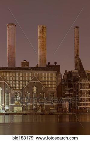Stock Photo - Factory smokestacks lit up at night. Fotosearch