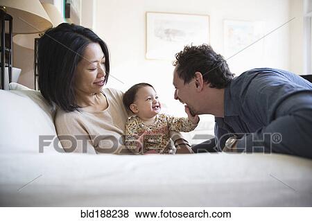 Stock Photo - Family playing on sofa. Fotosearch