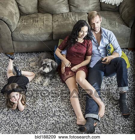 Stock Photo - Family relaxing in living room. Fotosearch