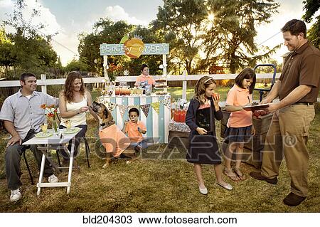 Stock Image - Family relaxing together outdoors. Fotosearch
