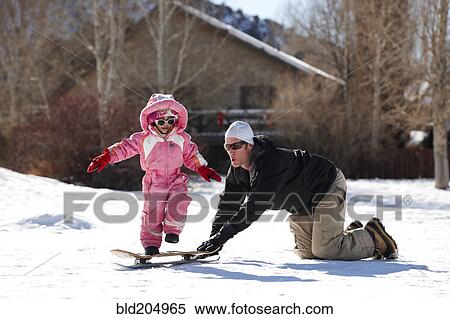 Stock Photography - Father and daughter playing in snow. Fotosearch