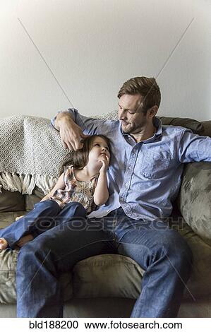 Father and daughter sitting on sofa View Large Photo Image Stock Image - Father and daughter sitting on sofa. Fotosearch
