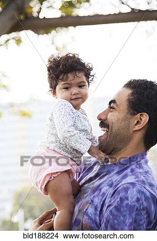 Picture - Father holding baby son outdoors. Fotosearch