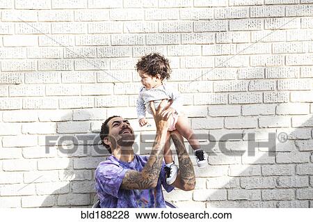 Father playing with baby son outdoors View Large Photo Image Stock Photo - Father playing with baby son outdoors. Fotosearch