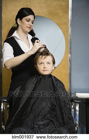 Stock Photo - Female hair stylist cutting child's hair. Fotosearch