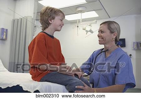 Stock Image - Female medical professional examining boy. Fotosearch