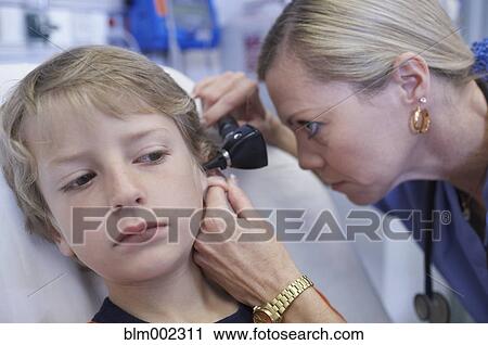 Stock Image - Female medical professional examining boy. Fotosearch
