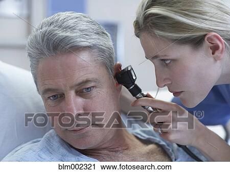Stock Image - Female medical professional examining patient. Fotosearch