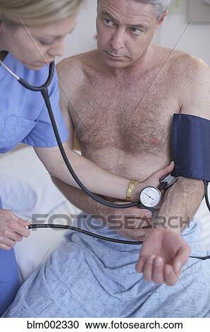 Stock Image - Female medical professional examining patient. Fotosearch
