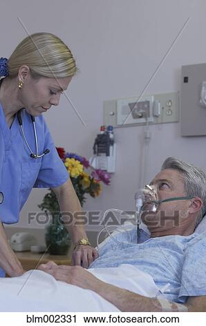 Stock Image - Female medical professional examining patient. Fotosearch