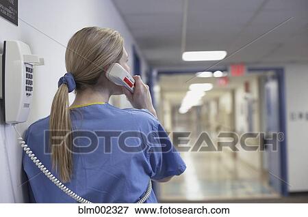 Stock Photo - Female medical professional talking on telephone. Fotosearch