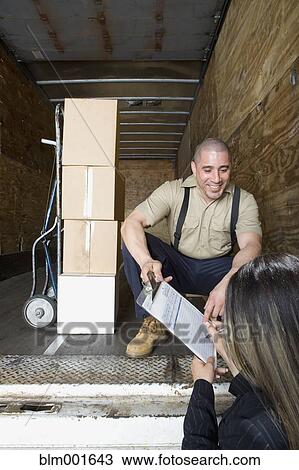 Female warehouse supervisor signing paperwork for male warehouse worker View Large Photo Image Stock Image - Female warehouse supervisor signing paperwork for male warehouse worker. Fotosearch