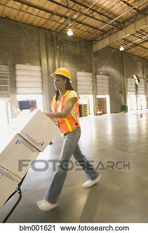 Female warehouse working pushing boxes on hand truck View Large Photo Image Stock Image - Female warehouse working pushing boxes on hand truck. Fotosearch