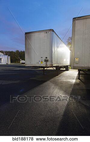 Stock Photo - Flat bed truck trailers in parking lot. Fotosearch
