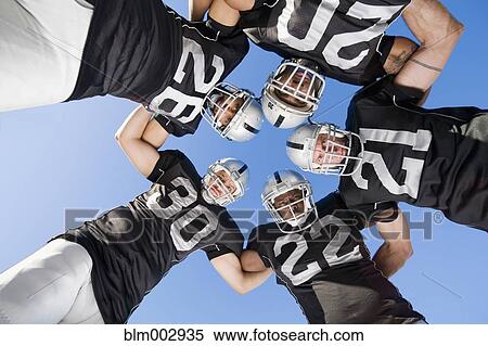 Stock Photography - Football players in huddle. Fotosearch