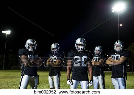 Stock Image - Football players in uniform with arms crossed. Fotosearch