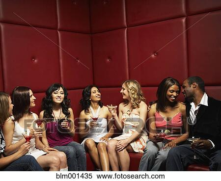 Stock Photography - Friends drinking cocktails in nightclub. Fotosearch