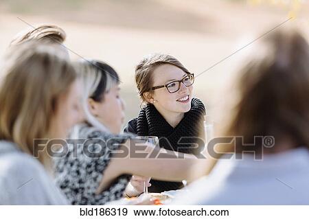 Stock Photo - Friends eating at outdoor table. Fotosearch