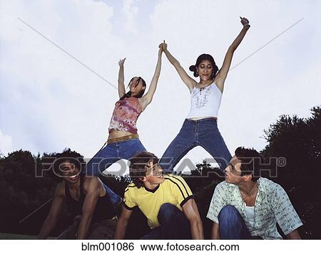 Stock Photograph - Friends making human pyramid. Fotosearch