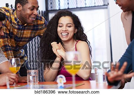 Friends playing board game at party View Large Photo Image Stock Photograph - Friends playing board game at party. Fotosearch